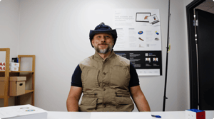 Engineer in fishing gear smiling at the office, showing how Allsolve frees up time for other plans.