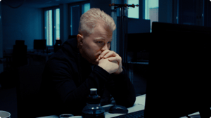 A tired engineer looking at his computer screen.