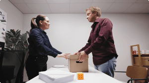 Allsolve handing the engineer a box, both smiling